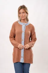 Saco marrón de tejido de punto con detalles en relieve y borde celeste. Tiene cuello redondo, cierre con botones de madera y mangas largas.