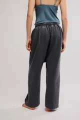 Pantalón harem amplio color gris oscuro con efecto lavado, tiro caído, cintura elástica con cordón de ajuste y grandes bolsillos parche en la parte delantera.