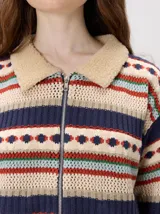 Campera de punto con cierre frontal metálico y cuello de corderito. Presenta un diseño tejido con franjas horizontales multicolores que incluyen patrones geométricos y texturas variadas.
