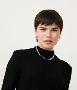 Polera color camel de punto acanalado, con cuello alto y mangas largas.