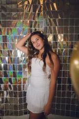 Minivestido blanco con un solo hombro, corte a la cintura y falda con volados.