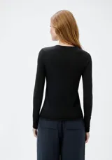 Blusa de punto tejido liviano color azul, de mangas largas y cuello redondo.