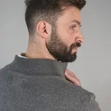 Campera tejida color marrón claro con cierre frontal, cuello alto y mangas largas con puños acanalados.