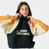 Polo de manga larga Eme Studios con diseño racing, confeccionado en algodón pesado. Presenta cuello tipo polo con cierre de botones, mangas raglán y paneles en colores amarillo, blanco y azul. Incluye logo bordado en el frente y detalles gráficos en las mangas.