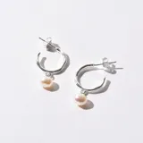 Par de aros plateados tipo argolla con perla colgante.