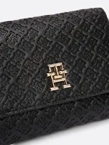 Billetera Tommy Hilfiger negra con diseño plegable en tres partes y monograma TH en bajo relieve. Cuenta con cierre de solapa con botón a presión, compartimento interior para billetes y múltiples ranuras interiores para tarjetas.