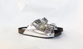 Sandalias plateadas con tres tiras ajustables con hebilla y plantilla anatómica negra.