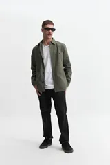 Sobrecamisa verde militar de twill de algodón, con cuello clásico, cierre frontal con botones a tono, dos bolsillos tipo parche con solapa abotonada en el pecho, mangas largas con puños abotonados y corte recto.