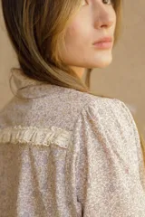 Camisa de algodón con estampado floral, cuello clásico, cierre frontal con botones, mangas largas con puños con volados y corte recto.