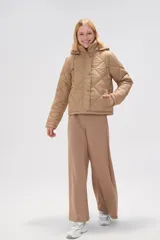 Campera acolchada de color negro con diseño de rombos, manga larga, capucha ajustable con cordones y cierre frontal con botones a presión.