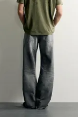 Jeans de denim de algodón en color azul con efecto desgastado, tiro medio y corte recto de ajuste holgado (loose fit). Cuenta con diseño clásico de cinco bolsillos y cierre frontal con cremallera y botón.