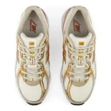 Championes New Balance modelo 740, con diseño inspirado en el running de los años 2000. Presenta una parte superior de malla abierta en color crema con superposiciones sintéticas en tonos naranja y dorado, logotipo N lateral en TPU y entresuela blanca con tecnología ABZORB para amortiguación.