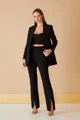 Pantalón negro de vestir con corte recto y aberturas en el ruedo.