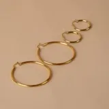 Aros tipo argolla de oro 18k con diseño torneado y acabado brillante.