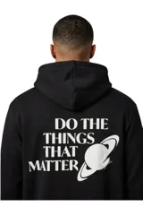 Buzo canguro negro con capucha, confeccionado en mezcla de poliéster y algodón. Cuenta con un gran estampado en la espalda en color blanco con la frase "DO THE THINGS THAT MATTER" y el gráfico de un planeta estilo Saturno.