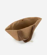 Bolso de playa tipo tote de paja color beige con asas de tela marrón.