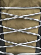 Mochila color arena con detalles en gris y negro. Cuenta con un compartimento principal con cierre, un bolsillo frontal con cordón elástico y bolsillos laterales de malla.