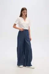 Pantalon de lyocell de tiro alto y corte ancho, con diseño de pinzas frontales y costuras verticales decorativas.