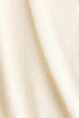 Top corto sin mangas de tejido de punto color blanco, con escote en V pronunciado, diseño frontal cruzado y dobladillo acanalado.