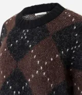 Suéter de punto pesado con diseño de cuadros argyle en tonos marrón y negro, con detalles de puntos claros. Presenta un corte oversize, cuello redondo acanalado y mangas largas.