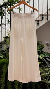 Pantalón de corte piyamero, con cintura ancha elastizada, bolsillos aplicados en la parte trasera y detalles en hilo al tono.