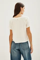 Remera de algodón color crudo con estampa frontal multicolor con la frase 'BOOGIE NIGHTS' en tipografía con efecto arcoíris. Presenta mangas ranglan y cuello redondo.