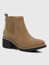 Bota tipo Chelsea de Hush Puppies, confeccionada en material sintético efecto gamuza color marrón. Presenta elásticos laterales al tono para facilitar el calce, suela robusta de goma negra con plataforma y taco ancho.