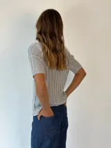 Top de lurex color naranja, con cuello en V y mangas cortas.