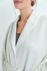 Bata de estar por casa con diseño acolchado, cuello solapa, mangas largas y lazo ajustable en la cintura. Cuenta con bolsillos frontales aplicados.