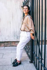 Zapato tipo blucher de pelo de pony en color negro con salpicaduras doradas. Presenta cierre de cordones, ribetes dorados a contraste y una silueta geométrica con aberturas laterales. Cuenta con un tacón bajo forrado en el mismo material.