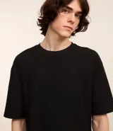 Remera color crema, de corte holgado, con cuello redondo y mangas cortas.