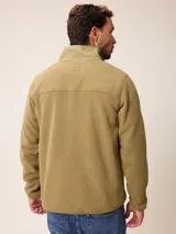 Campera de polar color verde militar, con cierre frontal completo, cuello alto y bolsillo en el pecho con cierre y detalle en tela técnica.