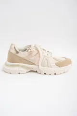 Zapatilla deportiva de diseño urbano en tonos neutros, combinando paneles de malla, gamuza y detalles metalizados en color dorado. Cuenta con suela robusta y acordonado frontal.