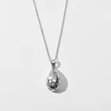 Collar plateado con dije en forma de lágrima con incrustaciones de strass en forma de estrellas.