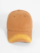 Gorra de béisbol color marrón claro con visera curva y bordado frontal con la inscripción "One Day" en amarillo.