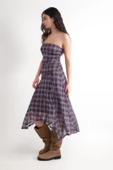 Vestido midi de palabra de honor con estampado de cuadros en tonos morados y beige. Presenta fruncidos en los laterales y un bajo asimétrico.