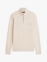 Sweater de punto color beige con cuello perkins, cierre frontal con cremallera corta y manga larga. Presenta detalles de rib en cuello, puños y dobladillo, además del logo bordado en el pecho de Tommy Hilfiger.