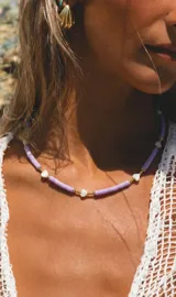 Collar de discos de fimo lila, con dijes de nácar en forma de corazón y pequeñas cuentas doradas.