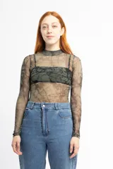 Remera de tul transparente con cuello alto y estampado abstracto en tonos verdes y marrones.