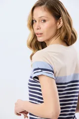 Remera de algodón de manga corta con diseño de bloques de color y rayas horizontales en tonos beige, celeste y azul marino, con cuello redondo.