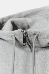 Cazadora de estilo deportivo con capucha ajustable, cierre frontal de doble cremallera y mangas abullonadas con puños elásticos. Presenta bolsillos delanteros y bajo elástico.