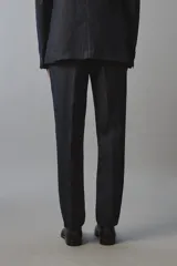 Pantalón de traje regular fit de lino color verde militar, con bolsillos laterales y bolsillos traseros de doble vivo con botón. Cierre frontal con cremallera y botón.