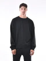 Buzo negro de corte holgado, con cuello redondo y mangas largas.