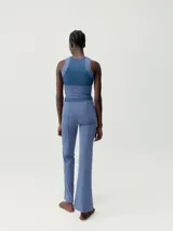 Legging flare largo de color negro, confeccionado en tejido Skin_Move. Presenta cinturilla ancha de doble tejido y un panel decorativo de malla transpirable en el centro del torso.