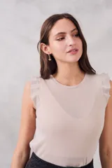 Musculosa color crudo de lurex, con cuello redondo y mangas con volados.