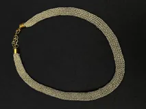 Collar de cadena con trama tipo malla o cuerda en tono dorado, con cierre de mosquetón y cadena de alargue.