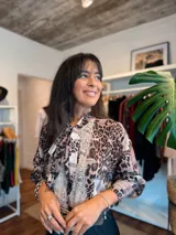 Camisa de manga larga con estampado animal print y detalles de encaje en el frente. Presenta un cuello con lazo integrado y un diseño fluido y elegante.