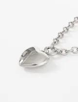 Collar con cadena de eslabones gruesos plateados y un dije colgante de corazón liso y pulido.