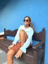 Bermuda de cuero sintético en color marrón, con diseño de corte recto, tiro medio y costuras verticales decorativas en el frente.