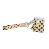 Billetera elástica de tejido resistente color beige con estampado de lunares marrones. Incluye argolla metálica lateral para llavero.